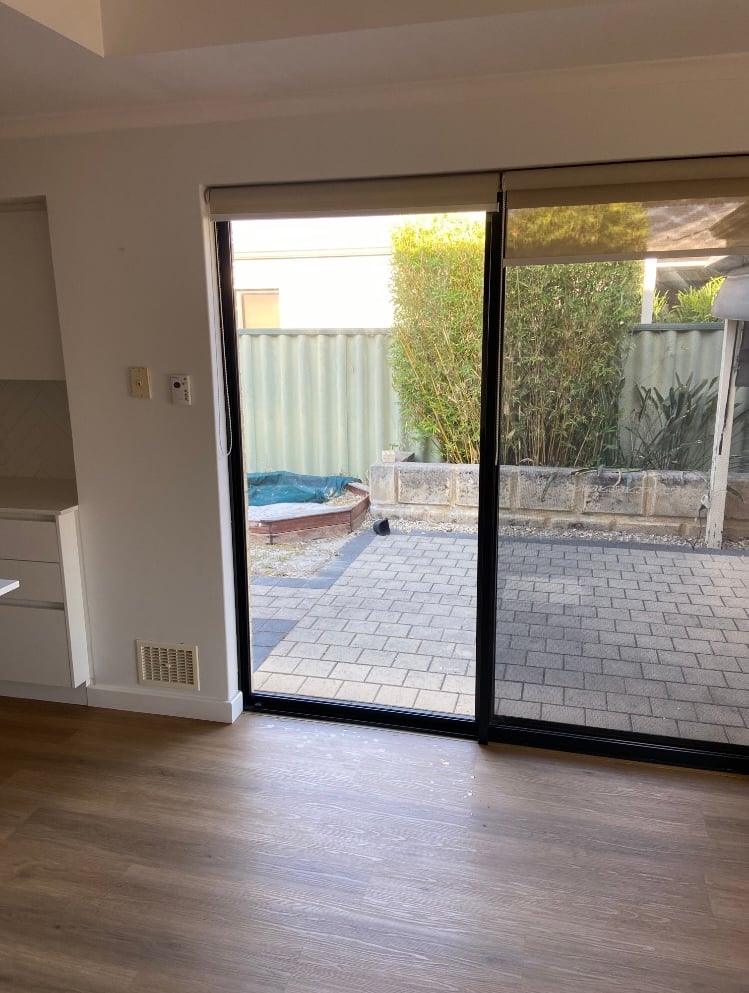 Sliding glass door with new glass opening onto a backyard
