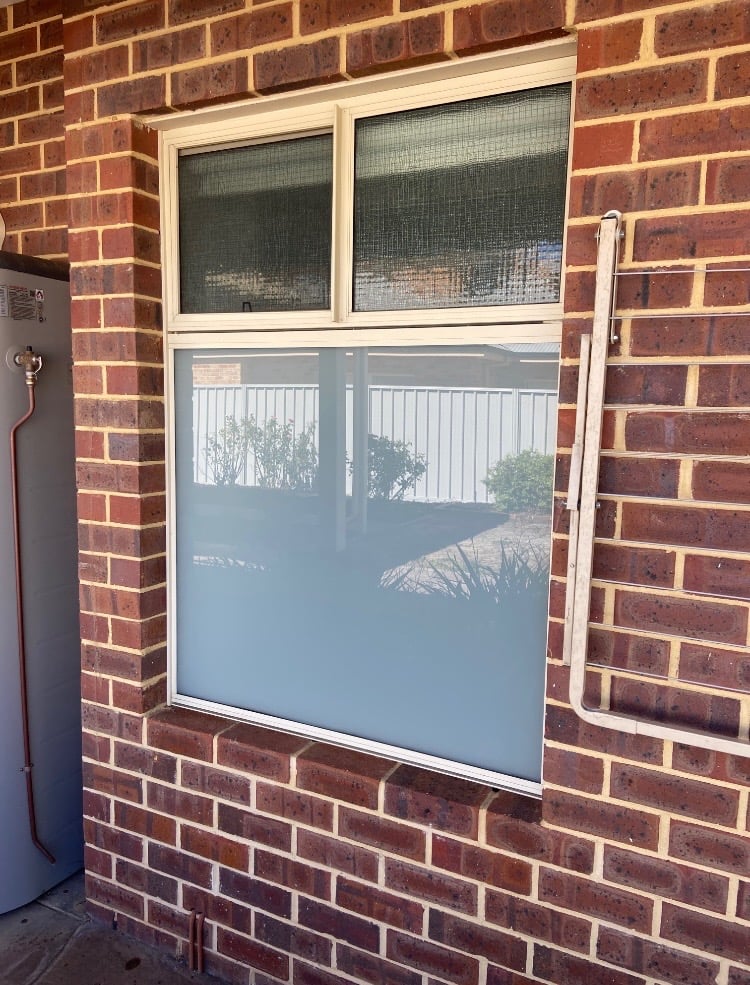 Frosted glass window installed in a brick home